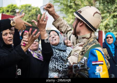 (140114) -- CAIRO, Jan. 14, 2014 (Xinhua) -- A Soldier gives tickets written as THANKS FOR COOPERATION WITH US to supporters of Egyptian Army and Army chief General Abdel Fattah al-Sisi outside a polling station in Cairo, Egypt, Jan. 14, 2014. Egyptians started casting their votes on Tuesday on the country s new draft constitution, which is widely seen as a milestone during Egypt s political transition after Islamist president Mohamed Morsi was ousted last July. (Xinhua/Pan Chaoyue) (dzl) EGYPT-CAIRO-VOTE-CONSTITUTION PUBLICATIONxNOTxINxCHN   Cairo Jan 14 2014 XINHUA a Soldier Gives Tickets wr Stock Photo