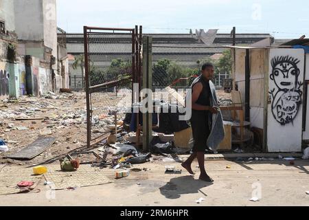 (140114) -- SAO PAULO, Jan. 14, 2014 (Xinhua) -- A man walks in front of a wasteland in the Luz neighborhood, also known by the residents as Crackland , in Sao Paulo, Brazil, on Jan. 14, 2014. In the recent years the country experiences a public health emergency according to the high growth of human outdoors establishments named like Crackland in the urban centers of the big cities like Sao Paulo and Rio de Janeiro, where hundreds of people gather to use drugs. The Sao Paulo City Hall announced last week a program that will begin to offer jobs and housing for the drug users in the region to un Stock Photo