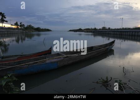 Traditionelles Holzboot auf dem Wasser des Lake Limboto, Gorontalo, Indonesien. Kleines hölzernes Ruderboot auf einem ruhigen See Stockfoto