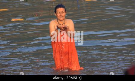 (140115) -- TANAHU, Jan. 15, 2014 (Xinhua) -- A devotee takes a holy dip in Narayani river during Maghe Sankranti Festival at Devghat in Tanahu district, Nepal, Jan. 15, 2014. Maghe Sankranti is one of the important festivals in Nepal, and is mostly marked by Nepali Hindus by taking ritual bath in confluence of rivers and offering worships in various temples, and eating special delicacies like chaku (hardened molasses), til ko laddu (sesame sweets) and tarul (yam). (Xinhua/Sunil Sharma) NEPAL-DEVGHAT-FESTIVAL PUBLICATIONxNOTxINxCHN   Jan 15 2014 XINHUA a devotee Takes a Holy Dip in Narayani Ri Stock Photo