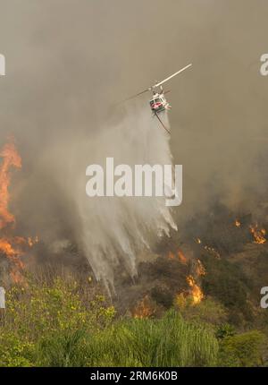 (140116) -- LOS ANGELES, 16. Januar 2014 (Xinhua) -- Ein Hubschrauber spritzt Wasser während einer Operation über dem Angeles National Forest, nördlich von Glendora, 16. Januar 2014. Das Colby-Feuer, das um 6 Uhr morgens als unkontrolliertes Lagerfeuer gemeldet wurde, ist auf 1.700 Acres gewachsen und verursachte dicken Rauch über der Region Los Angeles. (Xinhua/Yang Lei) US-LOS ANGELES-FOREST-FIRE PUBLICATIONxNOTxINxCHN Los Angeles Jan 16 2014 XINHUA A Helicopter sprüht Wasser während des Betriebs oberhalb des Angeles National Forest nördlich von Glendora Jan 16 2014 das Colby-Feuer meldete BEI etwa 6 A M, dass das Out of Control Camp Fire Stockfoto