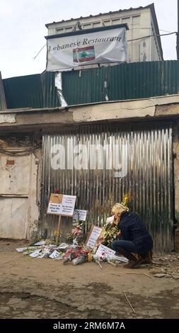 (140119) -- KABUL, 19. Januar 2014 (Xinhua) -- Eine Frau legt am 19. Januar 2014 Blumen vor dem Eingangstor des libanesischen Restaurants in Kabul, der Hauptstadt Afghanistans. Ein Selbstmordanschlag der Taliban auf ein libanesisches Restaurant, das bei Ausländern beliebt ist, am Freitagabend in dem befestigten Teil der afghanischen Hauptstadt, bei dem 21 Menschen, darunter 13 Ausländer, getötet wurden, hat die Befürchtungen, dass sich eine irakische Situation in Afghanistan wiederholen könnte, nachdem die von den USA geführten Koalitionstruppen den Konflikt verlassen haben, wieder aufleben lassen Land bis zum Jahresende (Xinhua/Zhao Yishen) AFGHANISTAN-KABUL-ATTENTAT-TRAUER PUBLICATIONxNOTxINxCH Stockfoto
