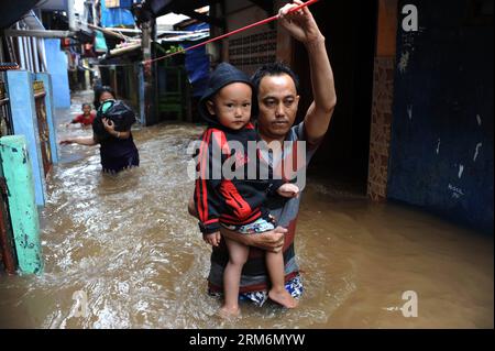 (140121) -- JAKARTA, Jan. 21, 2014 (Xinhua) -- A father and his family wade through floodwater in Kampung Melayu in Jakarta, Indonesia, Jan. 21, 2013. Flood caused by heavy downpour has killed eight people and forced over 60,000 others to escape from their home in Jakarta, official said. (Xinhua/Veri Sanovri)(zhf) INDONESIA-JAKARTA-FLOOD PUBLICATIONxNOTxINxCHN   Jakarta Jan 21 2014 XINHUA a Father and His Family Calf Through flood water in Kampung nacktesPerson Melayu in Jakarta Indonesia Jan 21 2013 Flood CAUSED by Heavy downpour has KILLED Eight Celebrities and Forced Over 60 000 Others to E Stock Photo