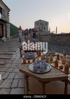 Touristen und Souvenirs auf Stari Most (Alte Brücke) an einem Sommerabend in Mostar, Bosnien und Herzegowina, 22. August 2023. Stockfoto