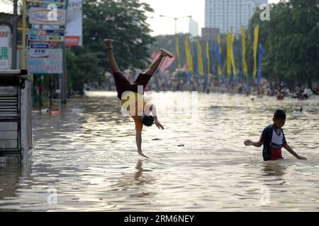 (140122) -- JAKART, 22. Januar 2014 (Xinhua) -- Kinder spielen in der überfluteten Gegend in Jakarta, Indonesien, 22. Januar 2014. In der indonesischen Hauptstadt Jakarta haben einige der Vertriebenen begonnen, ihre Häuser zu säubern, während die Überschwemmung zurückgeht, aber sie zögern immer noch, nachts zurückzukehren, so die Beamten. (Xinhua/Veri Sanovri) (zjl) INDONESIA-JAKARTA-FLOOD PUBLICATIONxNOTxINxCHN 22. Januar 2014 XINHUA Children Play in the Wlooded Area in Jakarta Indonesia 22. Januar 2014 in der indonesischen Hauptstadt Jakarta einige der vertriebenen Prominenten haben begonnen, ihre Häuser nach Cle zurückzugeben Stockfoto