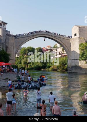 Jemand springt von Stari Most (Alte Brücke), während die Leute beobachten, dass dies ein Ritus der Durchfahrt in Mostar, Bosnien und Herzegowina, am 25. August 2023 ist. Stockfoto