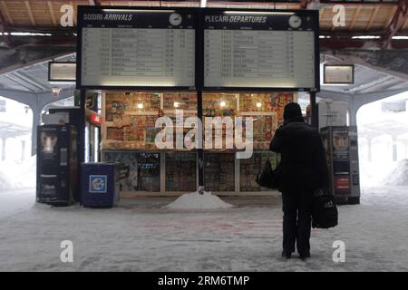 BUKAREST, 29. Januar 2014 (Xinhua) -- Ein Bürger schaut auf den Bahnfahrplan am Hauptbahnhof in Bukarest, Hauptstadt Rumäniens, 29. Januar 2014. Ein neuer schwerer Schneesturm am Mittwoch begann, die rumänische Hauptstadt sowie den Süden und Südosten zu treffen. Die rumänischen Behörden haben in vier weiteren Bezirken Ialomita, Calarasi, Constanta und Tulcea den Ausnahmezustand ausgerufen, um eine bessere Reaktion auf den aktuellen Schneesturm zu ermöglichen. (Xinhua/Gabriel Petrescu)(Axy) RUMÄNIEN-BUKAREST-SCHNEE NOTFALL PUBLICATIONxNOTxINxCHN Bukarest Jan 29 2014 XINHUA ein Bürger schaut AUF Zug Zeit Tabelle AN der Hauptbahn Stockfoto