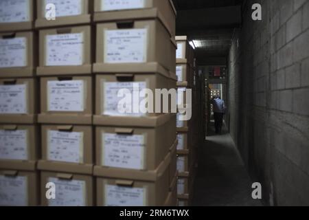 GUATEMALA CITY, 29. Januar 2014 (Xinhua) -- Ein Arbeiter läuft zwischen den Kisten mit Dokumenten im Historischen Archiv der Nationalpolizei (AHPN, für sein Akronym auf Spanisch), in Guatemala City, Hauptstadt von Guatemala, am 29. Januar 2014. Die AHPN wurde zufällig am 2005 in einer alten Sprengstofflagerstätte der National Civil Deposit (PNC) gefunden. Das Archiv verfügt über etwa 80 Millionen Blätter, die einen Zeitraum von 1881 bis 1997 abdecken, als die Nationalpolizei aufhörte zu existieren und die PNC entstand. Die Dokumente offenbarten die Art und Weise, wie die Nationalpolizei während des bewaffneten Konflikts in Guatema operierte Stockfoto