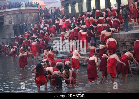 (140130) -- KATHMANDU, 30. Januar 2014 (Xinhua) -- nepalesische Hindu-Devotees nehmen ein heiliges Bad im Bagmati-Fluss am Ufer des Pashupatinath-Tempels während des Madhav Narayan Festivals in Kathmandu, Nepal, 30. Januar 2014. Nepalesische Hindu-Frauen beobachten ein Fasten und beten zu Göttin Swasthani und Gott Madhavnarayan für die Langlebigkeit ihrer Ehemänner und den Wohlstand ihrer Familie während des einmonatigen Festivals. (Xinhua/Sunil Sharma) NEPAL-KATHMANDU-MADHAV NARAYAN FESTIVAL PUBLICATIONxNOTxINxCHN KATHMANDU Jan 30 2014 XINHUA nepalesische Hinduweibchen nehmen ein Heiliges Bad im Bagmati-Fluss AM Ufer des Pashu Stockfoto