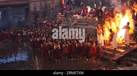 (140130) -- KATHMANDU, Jan. 30, 2014 (Xinhua) -- Nepalese female Hindu devotees offer prayers before a holy bath in the Bagmati river on the bank of Pashupatinath Temple during Madhav Narayan Festival in Kathmandu, Nepal, Jan. 30, 2014. Nepalese Hindu women observe a fast and pray to Goddess Swasthani and God Madhavnarayan for longevity of their husbands and family prosperity during the month-long festival. (Xinhua/Sunil Sharma) NEPAL-KATHMANDU-MADHAV NARAYAN FESTIVAL PUBLICATIONxNOTxINxCHN   Kathmandu Jan 30 2014 XINHUA Nepalese Female Hindu devotees OFFER Prayers Before a Holy Bath in The Ba Stock Photo