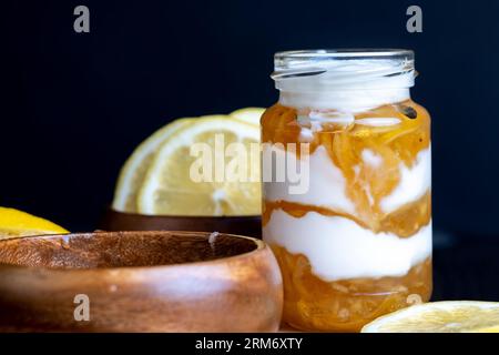 Joghurt aus frischer Milch mit süßer Zitronenmarmelade und frischen Zitronen, köstlicher Joghurt mit Zitronengeschmack Stockfoto