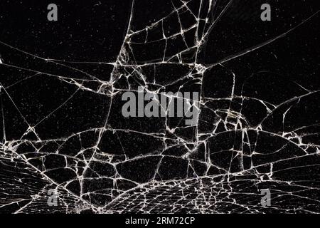 Verschmutztes Glas, das in eine große Anzahl von Teilen zerbrochen ist, ein Stück Glas mit vielen Rissen und gebrochenen Teilen Stockfoto