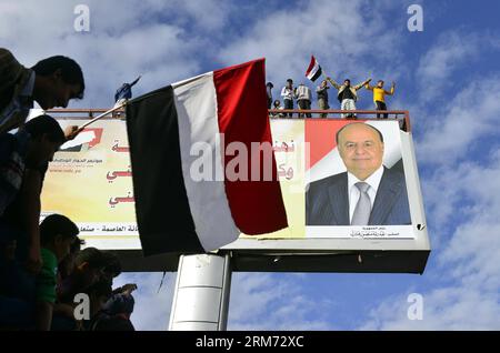 (140211) -- SANAA, 11. Februar 2014 (Xinhua) -- jemenitische Menschen halten eine Nationalflagge des Jemen unter einem riesigen Bild des jemenitischen Präsidenten Abd-Rabbu Mansour Hadi, während sie an einer Festveranstaltung in Sanaa, Jemen, am 11. Februar 2014 teilnehmen. Zehntausende von jemenitischen Menschen nahmen an der Veranstaltung zum Gedenken an den dritten Jahrestag der Revolution von 2011 Teil, die den ehemaligen Präsidenten Ali Abdullah Saleh zum Rücktritt zwang. (Xinhua/Mohammed Mohammed) JEMEN-SANAA-REVOLUTION-JAHRESTAG-FEIER PUBLICATIONxNOTxINxCHN SANAA 11. Februar 2014 XINHUA jemenitische Prominente halten eine nationale Flagge des Jemen unter einem riesigen PIC Stockfoto