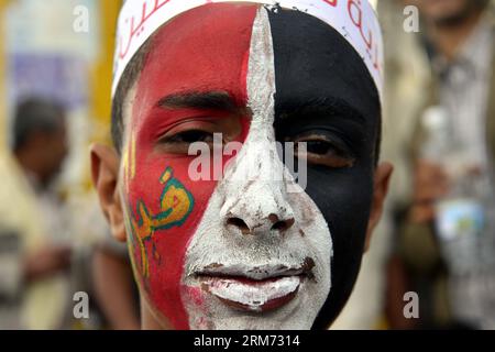 (140211) -- SANAA, 11. Februar 2014 (Xinhua) -- Ein jemenitischer Mann, der die jemenitische Nationalflagge auf sein Gesicht malt, nimmt am 11. Februar 2014 an einer Festveranstaltung in Sanaa, Jemen, Teil. Zehntausende von jemenitischen Menschen nahmen an der Veranstaltung zum Gedenken an den dritten Jahrestag der Revolution von 2011 Teil, die den ehemaligen Präsidenten Ali Abdullah Saleh zum Rücktritt zwang. (Xinhua/Mohammed Mohammed) JEMEN-SANAA-REVOLUTION-JAHRESTAG-FEIER PUBLICATIONxNOTxINxCHN SANAA 11. Februar 2014 XINHUA ein jemenitischer Mann, der die jemenitische Nationalflagge AUF sein Gesicht malt, nimmt AM 11. Februar an einer Feier in Sanaa Jemen Teil Stockfoto