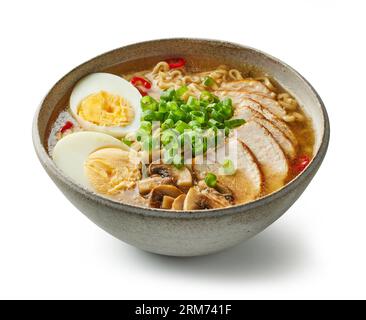 Schüssel mit asiatischer Ramen-Nudelsuppe mit Hühnchen, Eiern und Pilzen auf weißem Hintergrund Stockfoto