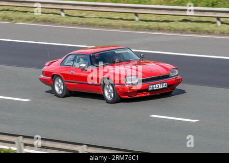 1993 roter Jaguar Benzinmotor mit 3980 ccm; Fahrt mit Höchstgeschwindigkeit auf der Autobahn M6 im Großraum Manchester, Großbritannien Stockfoto