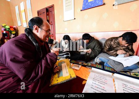 (140216) -- DARI, 15. Februar 2014 (Xinhua) -- Aang Jiancuo (1. L), Erbe der tibetischen Kalligraphie de ang Sazhi, unterrichtet Schüler in einem Klassenzimmer im de ang Tempel im Bezirk Dari der tibetischen Autonomen Präfektur Golog, Provinz Qinghai im Nordwesten Chinas, 15. Februar 2014. Aang Jiancuo, 46, ist der Erbe der tibetischen Kalligraphie de ang Sazhi, die als nationales immaterielles Kulturerbe Chinas aufgeführt wurde. Der Erbe lernte die Kalligraphie im Alter von 12 Jahren selbst und folgte Bazhi, dem siebten Erben von de ang Sazhi Kalligraphie ab 27 Jahren. Derzeit ist die 46-jährige Stockfoto