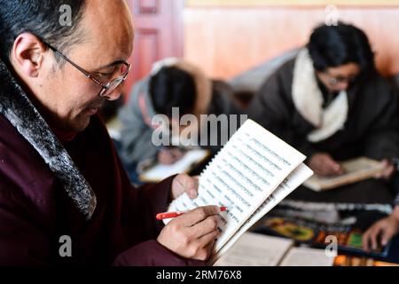 (140216) -- DARI, Feb. 15, 2014 (Xinhua) -- Aang Jiancuo, inheritor of De ang Sazhi Tibetan Calligraphy, looks through assignment of students at a classroom in the De ang Temple in Dari County of Tibetan Autonomous Prefecture of Golog, northwest China s Qinghai Province, Feb. 15, 2014. Aang Jiancuo, 46, is the inheritor of the De ang Sazhi Tibetan Calligraphy, which has been listed as the national intangible culture heritage of China. The inheritor learned the calligraphy by himself at the age of 12 and followed Bazhi, the seventh heir of De ang Sazhi Calligraphy from 27 years old. Currently, Stock Photo