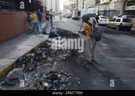 (140217) -- MIRANDA, 17. Februar 2014 (Xinhua) -- ein Mitarbeiter durchstreift am 17. Februar 2014 die Straße vor dem Hauptquartier des öffentlichen Fernsehsenders Venezuelan in Caracas, Venezuela. In den letzten Abenden versammelten sich gewalttätige Demonstranten um das Hauptquartier des venezolanischen Fernsehens (VTV), zündeten Feuer in den Straßen an und schleuderten Steine und Molotow-Cocktails. (Xinhua/AVN) VENEZUELA-MIRANDA-SOCIETY-PROTEST PUBLICATIONxNOTxINxCHN Miranda 17. Februar 2014 XINHUA to Employee fegt die Straße vor dem Hauptquartier des öffentlichen Netzwerks Venezuelan Television in Caracas Venezuela an Stockfoto