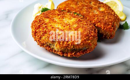 Zwei Hähnchenschnitzel auf einem Blatt Salat, Kartoffelpüree und Tomatensoße. Koteletts nach Kiew-Art Stockfoto