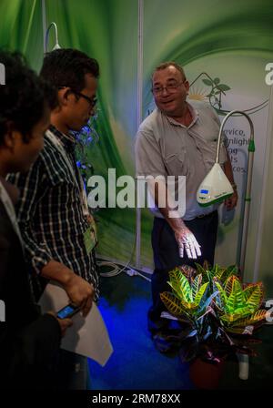 AIRPORT CITY (ISRAEL), 18. FEBRUAR 2014 -- ein Mitarbeiter von Wekah Technologies Ltd. stellt Wekah Sun vor, ein intelligentes Beleuchtungsgerät, energiesparend und Sonnenlicht, das das Wachstum von Pflanzen in Häusern und Büros ersetzt und ermöglicht, während des 18. jährlichen internationalen Gipfels und der Ausstellung für Wassertechnologien, Energieeffizienz, erneuerbare Energien, Erdgas, Recycling, Green Transportation and Green Building (CLEANTECH2014) im Avenue Congress and Exhibition Center in Airport City, Israel, am 18. Februar 2014. Die minimale Lichtstromstärke, die für in Innenräumen angebaute Topfpflanzen benötigt wird, beträgt 100-150 Mio. Stockfoto