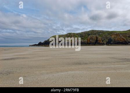An einem bewölkten Tag im Juni auf der Isle of Lewis in südlicher Richtung zur Landzunge an einem Ende des Garry Beach, mit den Felsvorsprüngen, die auf der flachen sa verstreut sind Stockfoto