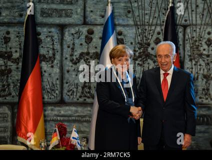 JERUSALEM, 25. Februar 2014 (Xinhua) -- der israelische Präsident Shimon Peres (R) schüttelt die Hand mit der deutschen Kanzlerin Angela Merkel, nachdem sie ihr am 25. Februar 2014 bei einer Pressekonferenz in der Residenz des israelischen Präsidenten in Jerusalem die Präsidentenmedaille verliehen hatte. Merkel traf sich am Dienstag hier mit dem israelischen Präsidenten Shimon Peres, der Merkel die Präsidentenmedaille verlieh – die höchste zivile Ordnung für ihr unerschütterliches Engagement für Israels Sicherheit und den Kampf gegen Antisemitismus und Rassismus, insbesondere durch Bildung. Merkel kam für in Israel an Stockfoto