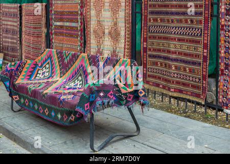Vielfalt der herrlichen orientalischen Teppiche im traditionellen Teppichgeschäft in Tiflis, Georgia. Viele schöne handgefertigte Teppiche auf dem traditionellen Markt Stockfoto