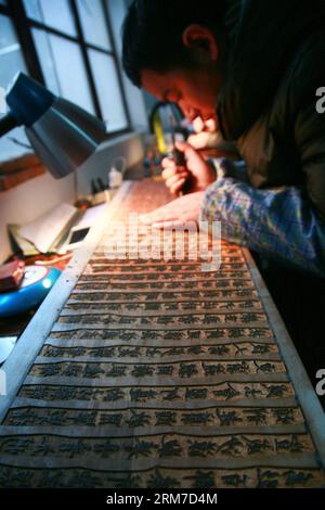 YANGZHOU, 25. Februar 2014 (Xinhua) -- Ein Arbeiter macht die Schnitzerei bei der Guangling Ancient Books Printing Society in Yangzhou, ostchinesische Provinz Jiangsu, 25. Februar 2014. Die Technik des Blockdrucks mit einer Geschichte von über 2.000 Jahren wurde 2006 als staatliches immaterielles Kulturerbe Chinas aufgeführt. Um die Technik besser zu schützen, wurde 1958 in Yangzhou die Guangling Ancient Books Printing Society gegründet. Die Gesellschaft hat die einzige vollständige Blockdrucktechnik in China beibehalten. (Xinhua/Cui Genyuan) (MP) CHINA-JIANGSU-YANGZHOU-BLOCK PRINTING (CN) PUBLICATIONxNOTxINxCH Stockfoto