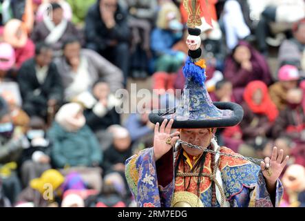 (140228) -- LHASA, Feb. 28, 2014 (Xinhua) -- A Tibetan Buddhist monk tames evil spirits with a chain during a Cham dance ritual held to celebrate the upcoming Losar at the Tsurphu Monastery in Doilungdeqen County of Lhasa, capital of southwest China s Tibet Autonomous Region, Feb. 28, 2014. The Cham dance is a ritual performed by Tibetan Buddhist monks to exorcise evil spirits. The dancers wear masks of various animals and mythical figures as they perform to the accompaniment of religious music. At the Tsurphu Monastery, a main base of the Kagyu school in Tibetan Buddhism, the Cham dance is us Stock Photo