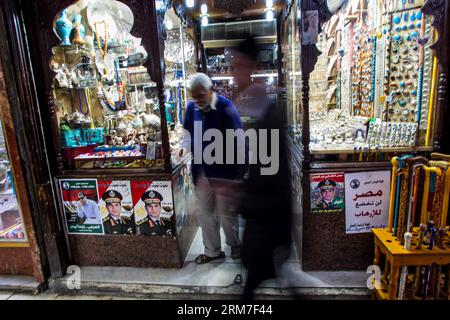 (140301) -- KAIRO, 1. März 2014 (Xinhua) -- Ägypter kommen am 1. März 2014 an Plakaten des Feldes marschall Abdel-Fattah al-Sisi im Stadtteil Khan-Al Khalili in Alt-Kairo, Ägypten vorbei. Amr Moussa, der Vorsitzende des 50-köpfigen Verfassungsentwurfs, sagte, dass der feldmarschall Abdel-Fattah al-Sisi sein Präsidentenangebot in wenigen Tagen verkünden werde, so die staatliche Zeitung Al-Ahram am Freitag. (Xinhua/Amru Salahuddien) ÄGYPTEN-KAIRO-PRÄSIDENTENWAHL-AL-SISI PUBLICATIONxNOTxINxCHN Kairo 1. März 2014 XINHUA Ägypter Pass von Plakaten des Feldes Marschall Abdel Fattah Al Sisi i. Stockfoto