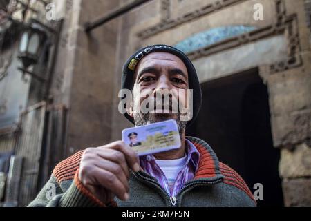 (140301) -- CAIRO, March 1, 2014 (Xinhua) -- An supporter of the field marshall Abdel-Fattah al-Sisi holds a common commercial fake ID of al-Sisi in Khan-Al Khalili neighborhood in Old Cairo, Egypt, on March 1, 2014. The head of the 50-member constitution-draft panel Amr Moussa said that the field marshall Abdel-Fattah al-Sisi would announce his presidential bid in a matter of days, according state-run Al-Ahram newspaper on Friday. (Xinhua/Amru Salahuddien) EGYPT-CAIRO-PRESIDENTIAL ELECTION-AL-SISI PUBLICATIONxNOTxINxCHN   Cairo March 1 2014 XINHUA to Supporter of The Field Marshall Abdel Fatt Stock Photo