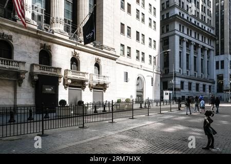 Blick auf das Fearless Girl, eine Bronzeskulptur auf der Broad Street gegenüber dem New York Stock Exchange Building in Manhattan, New York City. Stockfoto