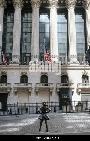 Blick auf das Fearless Girl, eine Bronzeskulptur auf der Broad Street gegenüber dem New York Stock Exchange Building in Manhattan, New York City. Stockfoto