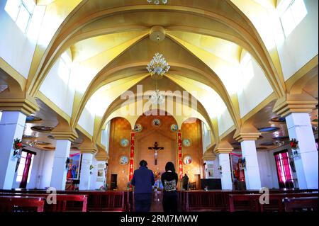 (140310) -- MARKAM COUNTY, 10. März 2014 (Xinhua) -- Katholiken beten in der Yanjing Catholic Church in Naxi Ethnic Group Township of Markam County unter der Präfektur Chamdo, der autonomen Region Tibet im Südwesten Chinas, 9. März 2014. Die 1865 gegründete katholische Kirche Yanjing (wörtlich Salzbrunnen) ist die einzige katholische Kirche, die in der Region noch in Gebrauch ist. Seine Architektur hat ein tibetisches Außendesign kombiniert mit einem gotischen im Inneren. Die Kirche hat einen Priester und zwei Schwestern, und hält Messen an Weihnachten und Ostern sowie wöchentliche Gottesdienste in tibetischer Sprache für seine 559 CA Stockfoto