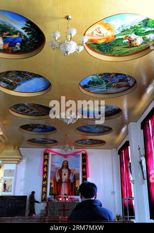 (140310) -- MARKAM COUNTY, 10. März 2014 (Xinhua) -- Katholiken beten in der Yanjing Catholic Church in Naxi Ethnic Group Township of Markam County unter der Präfektur Chamdo, der autonomen Region Tibet im Südwesten Chinas, 9. März 2014. Die 1865 gegründete katholische Kirche Yanjing (wörtlich Salzbrunnen) ist die einzige katholische Kirche, die in der Region noch in Gebrauch ist. Seine Architektur hat ein tibetisches Außendesign kombiniert mit einem gotischen im Inneren. Die Kirche hat einen Priester und zwei Schwestern, und hält Messen an Weihnachten und Ostern sowie wöchentliche Gottesdienste in tibetischer Sprache für seine 559 CA Stockfoto