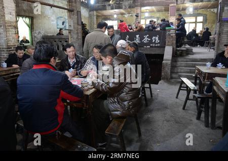 CHONGQING, 07. März 2014 (Xinhua) – Kunden genießen Tee, während sie Karten im Jiaotong Teehaus im Bezirk Jiulongpo der südwestchinesischen Gemeinde Chongqing spielen, 7. März 2014. Das Jiaotong Teehaus, das seit fast drei Jahrzehnten geschäftlich tätig ist, ist der beliebteste Ort für viele Teeliebhaber geworden, da viele andere Teehäuser in der Innenstadt von Chongqing geschlossen wurden. Viele Gäste bleiben hier für einen ganzen Tag, um typische Teehäuser zu unterhalten: Tee zu genießen, mit anderen zu plaudern, Karten zu spielen und sich an die alten Zeiten zu erinnern. (Xinhua/Zhou Hui) (lmm) CHINA-CHONGQING-LIFE-TEA HOUSE (CN) P Stockfoto
