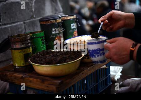 CHONGQING, 07. März 2014 (Xinhua) -- Eine Kellnerin serviert Tee für Kunden im Jiaotong Teehaus im Bezirk Jiulongpo der südwestchinesischen Gemeinde Chongqing, 7. März 2014. Das Jiaotong Teehaus, das seit fast drei Jahrzehnten geschäftlich tätig ist, ist der beliebteste Ort für viele Teeliebhaber geworden, da viele andere Teehäuser in der Innenstadt von Chongqing geschlossen wurden. Viele Gäste bleiben hier für einen ganzen Tag, um typische Teehäuser zu unterhalten: Tee zu genießen, mit anderen zu plaudern, Karten zu spielen und sich an die alten Zeiten zu erinnern. (Xinhua/Zhou Hui) (lmm) CHINA-CHONGQING-LIFE-TEA HOUSE (CN) PUBL Stockfoto
