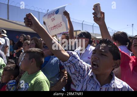 TIJUANA, 10. März 2014 (Xinhua) – Demonstranten auf mexikanischer Seite unterstützen die jungen Einwanderer, die Teil der Gruppe namens Träumer sind, während sie am 10. März 2014 am Grenzübergang Otay in Tijuana, Nordwest-Mexiko, in Richtung USA überqueren. Etwa 30 Menschen, die vom US-amerikanischen Verband Dreamactivist organisiert wurden, überquerten am Montag die Grenze in die Vereinigten Staaten und suchten politisches Asyl. (Xinhua/Guillermo Arias) MEXIKO-TIJUANA-US-GRENZMIGRANTEN PUBLICATIONxNOTxINxCHN Tijuana 10. März 2014 XINHUA-Demonstrant AUF MEXIKANISCHER Seite Unterstützen Sie die jungen Einwanderer, die Teil der Gruppe namens Dream sind Stockfoto