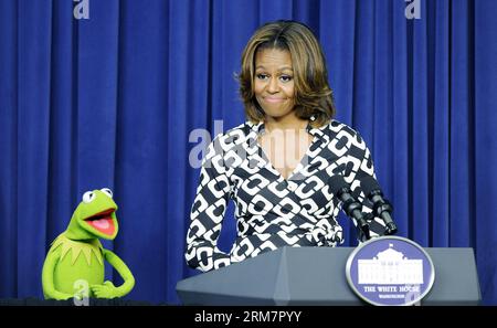 (140312) -- WASHINGTON D.C., 12. März 2014 (Xinhua) -- US-First Lady Michelle Obama, begleitet von Kermit der Frosch, spricht bei einer Sondervorführung von Disneys Film Muppets Most Wanted im Weißen Haus in Washington D.C., Hauptstadt der Vereinigten Staaten, 12. März 2014. Im Rahmen der Initiative „Joining Forces“ sprach First Lady Michelle Obama während der Sondervorführung an Kinder von Militärfamilien. (Xinhua/Bao Dandan) US-WASHINGTON-FIRST LADY-DISNEY-SCREENING PUBLICATIONxNOTxINxCHN Washington D C 12. März 2014 XINHUA U S First Lady Michelle Obama begleitet von Kermit The Stockfoto