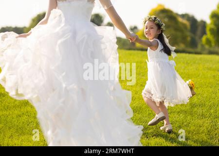 Schöne Braut mit Blumenmädchen Stockfoto