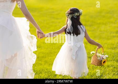 Schöne Braut mit Blumenmädchen Stockfoto