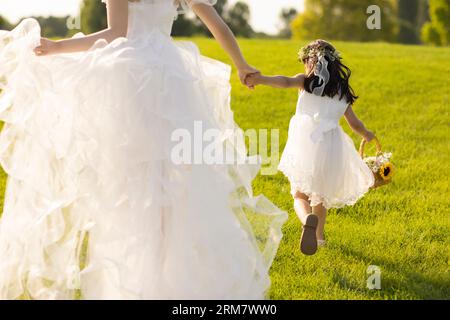 Schöne Braut mit Blumenmädchen Stockfoto