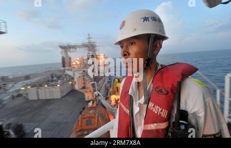 (140318) -- AN BORD DER NANHAIJIU 101, 18. März 2014 (Xinhua) -- Besatzungsmitglied des chinesischen Rettungsschiffs Nanhaijiu 101 Zhao Jun beobachtet, wie sich das Schiff Qiandaohu nähert, als beide nach Singapur fahren, um sich der Suche nach dem fehlenden Malaysia Airlines Flug MH370 am 18. März 2014 anzuschließen. Am Dienstag um 8:00 Uhr befahl das chinesische Verkehrsministerium allen chinesischen Schiffen im Golf von Thailand, in den Gewässern südöstlich der Bucht von Bengalen und in der Nähe der Sunda-Straße zu suchen. (Xinhua/Zhao Yingquan) NANHAIJIU 101-CHINA-RETTUNGSSCHIFFE PUBLICATIONxNOTxINxCHN Stockfoto
