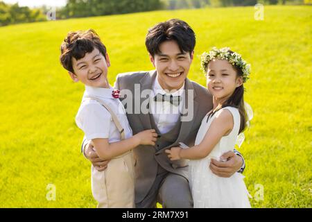 Fröhlicher Bräutigam mit Blumenmädchen und Ringträger Stockfoto