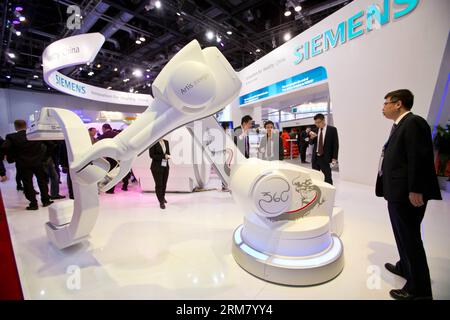 (140321) -- BEIJING, March 21, 2014 (Xinhua) -- Visitors look at a digital subtraction angiography (DSA) machine at the 26th International Medical Instruments and Equipment Exhibition in Beijing, capital of China, March 21, 2014. The three-day exhibition kicked off here Friday at China National Convention Center. (Xinhua/Zhao Bing)(wjq) CHINA-BEIJING-MEDICAL INSTRUMENTS & EQUIPMENT EXHIBITION (CN) PUBLICATIONxNOTxINxCHN   Beijing March 21 2014 XINHUA Visitors Look AT a Digital subtraction  Dsa Machine AT The 26th International Medical Instruments and Equipment Exhibition in Beijing Capital of Stock Photo