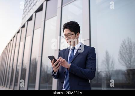 Zuversichtlich Geschäftsmann mit Smartphone Stockfoto