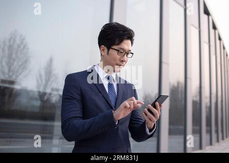 Zuversichtlich Geschäftsmann mit Smartphone Stockfoto