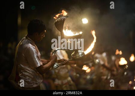 (140325) -- VARANASI, 25. März 2014 (Xinhua) -- Priester führen Ganges Aarti in Varanasi auf, einer alten und hinduistischen heiligen Stadt am Ufer des Ganges, Indien, 25. März 2014. Die Ganges Aarti ist die rituelle Zeremonie der Hindus, die ihr Engagement für die Flussgötter zeigt. Aufgrund seiner Dressings und seines einzigartigen Stils ist die großartige Veranstaltung zu einem muss in Varanasi geworden und zieht jeden Tag Touristen aus der ganzen Welt an. (Xinhua/Zheng HUANSONG) INDIA-VARANASI-GANGA AARTI PUBLICATIONxNOTxINxCHN Varanasi März 25 2014 XINHUA Priester führen Ganges Aarti in Varanasi zu Alt und H Stockfoto