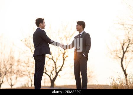 Selbstbewusste Geschäftsleute, die im Freien die Hände schütteln Stockfoto